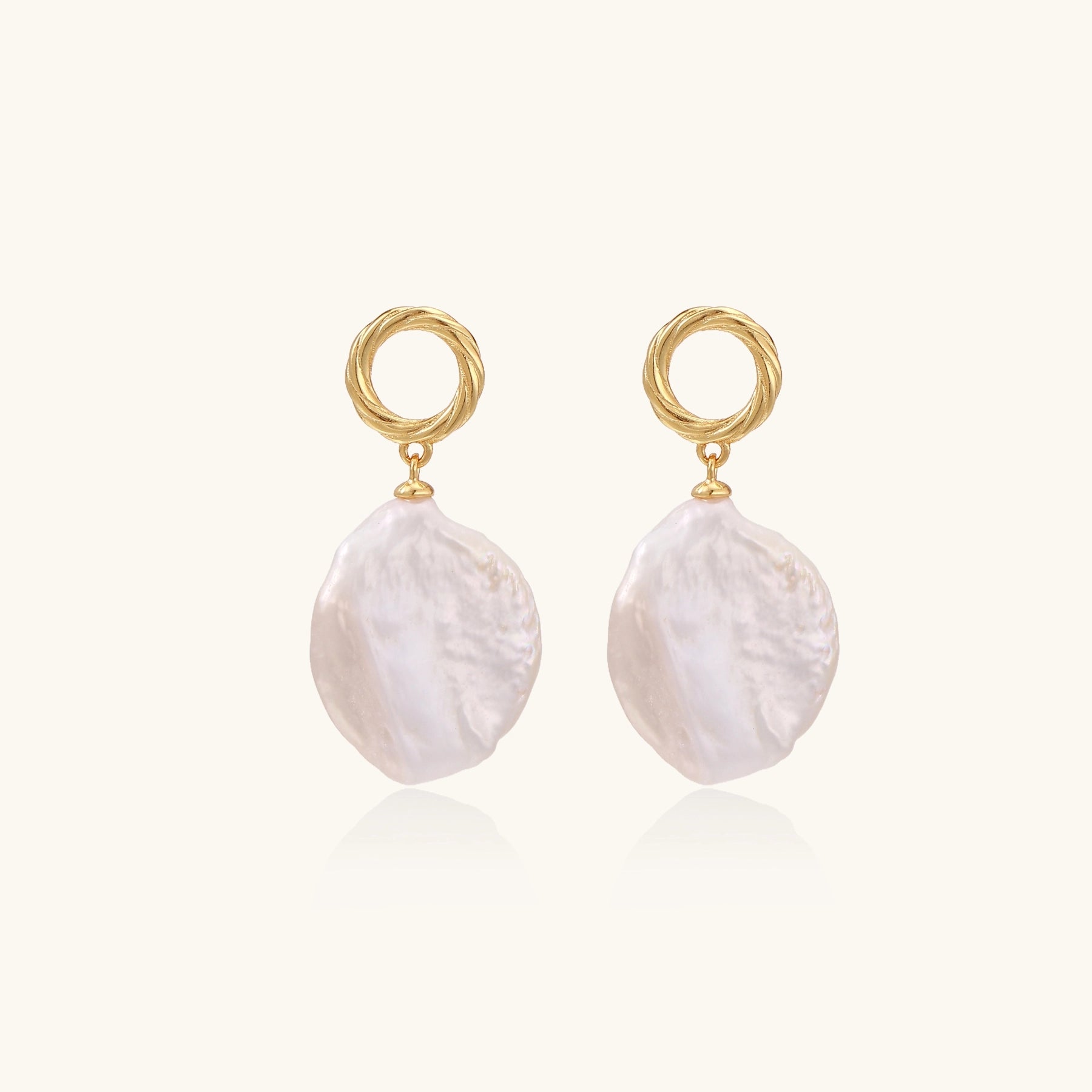 18K gold vermeil twisted circle studs with organic white baroque pearl drops on cream background