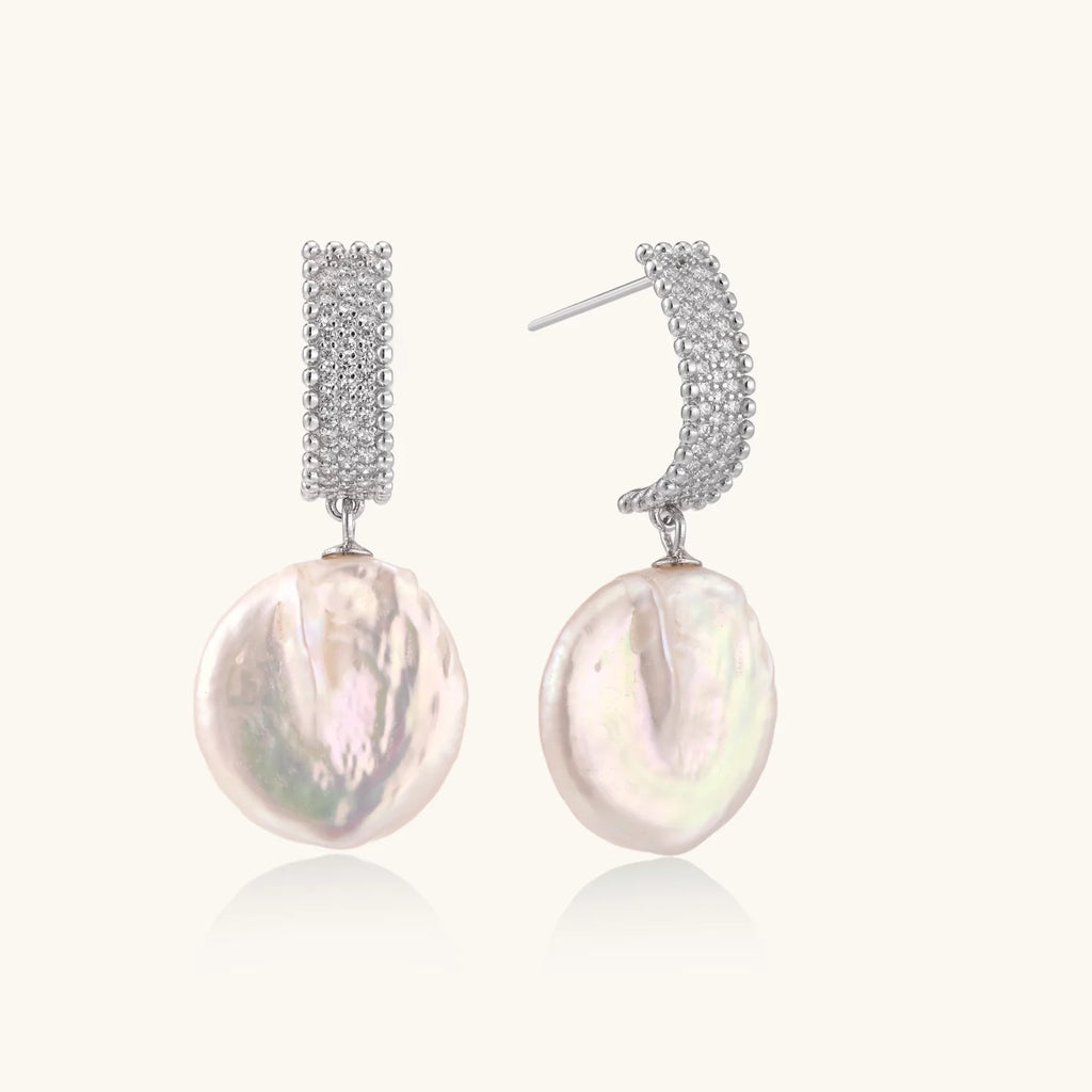Rhodium-plated silver curved stud with pave stones and baroque pearl drop on white background