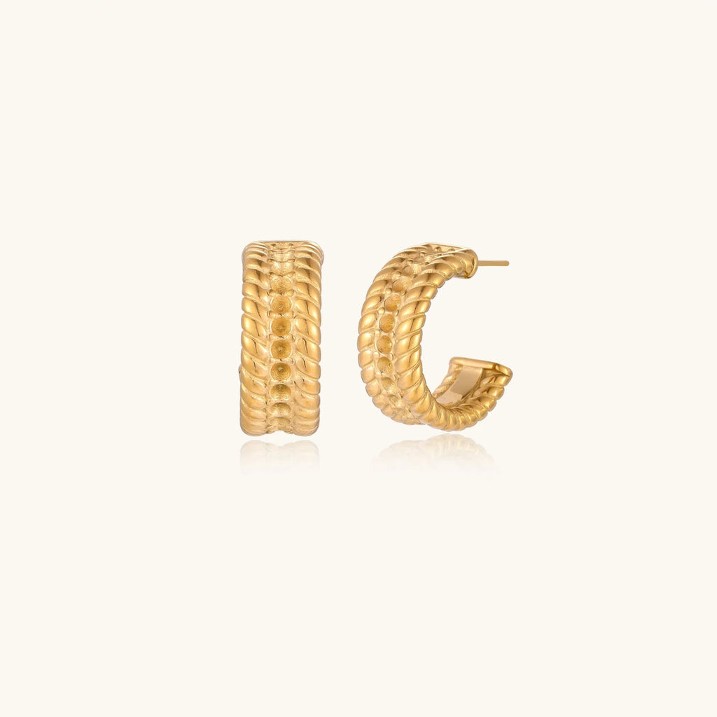Chunky gold hoops with dimensional ridged texture and 14K plated finish shown in front and side view on cream background.